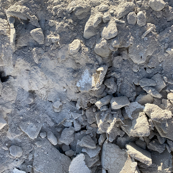 Nahaufnahme eines Haufens aus grauem Schutt und Steinen unterschiedlicher Größe und unregelmäßiger Form bei natürlichem Licht.