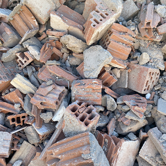 Ein Haufen zerbrochener roter Ziegel und Schutt mit unterschiedlichen Strukturen und Löchern, chaotisch verstreut.