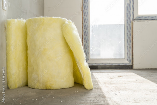 Ein weicher, flauschiger, gelber Sessel in einem hellen Raum mit großen Fenstern, auf einem Teppich in neutralen Tönen.